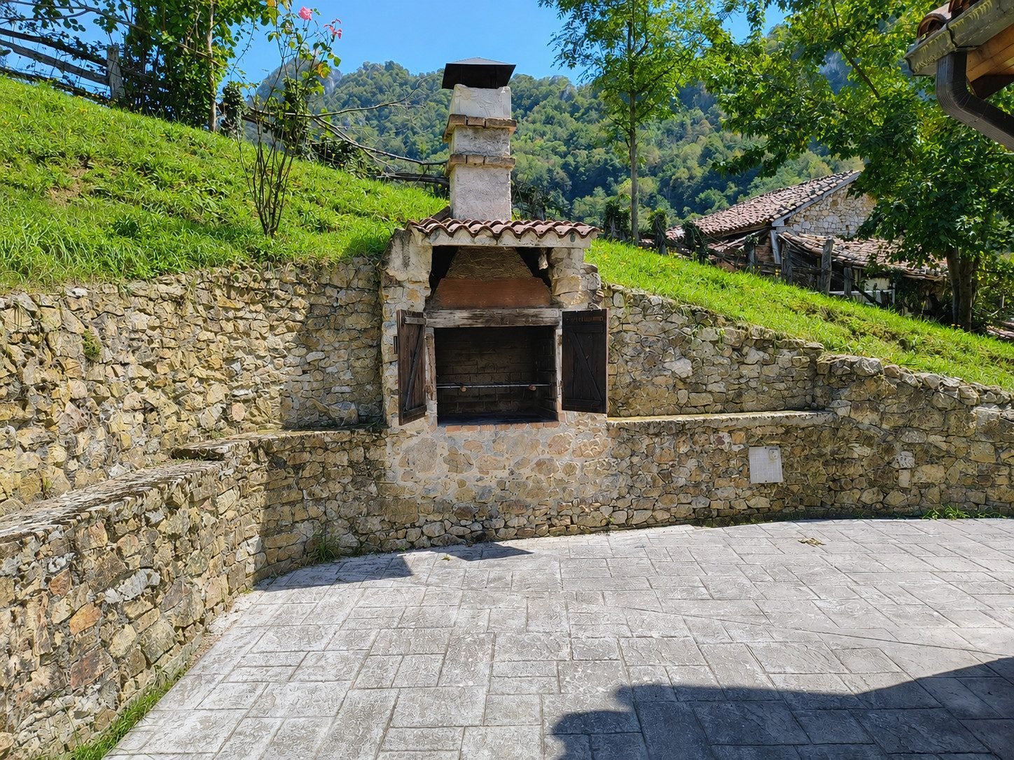 Stone barbecue on the terrace, with the valley behind